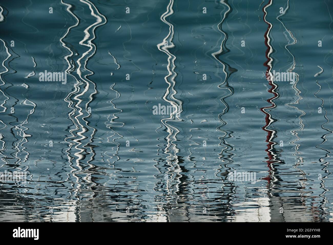 Riflessione di alberi di barche a vela sull'acqua, interessante struttura, linee d'acqua lisce, una regata velica, riflesso di alberi su wa Foto Stock Riflessione di alberi di barche a vela sull'acqua, interessante struttura, linee d'acqua lisce, una regata velica, riflesso di alberi su wa Foto Stock