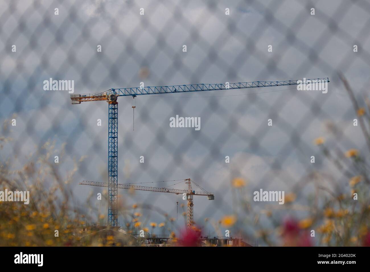 Quartiere in costruzione. Le gru disegnano delle geometrie nel cielo. Foto Stock