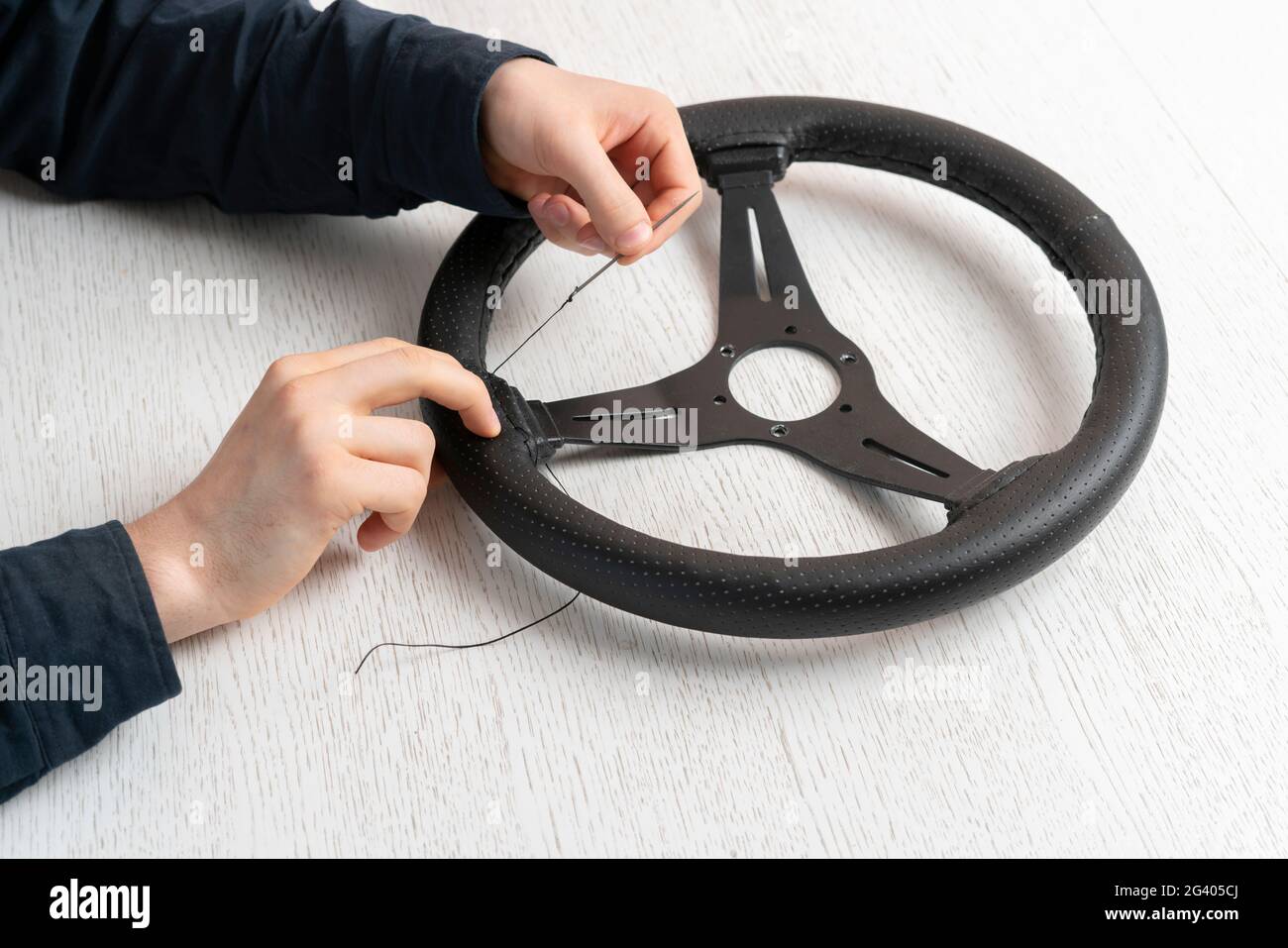 sostituire il rivestimento in pelle ecologica del volante della vettura, Foto Stock