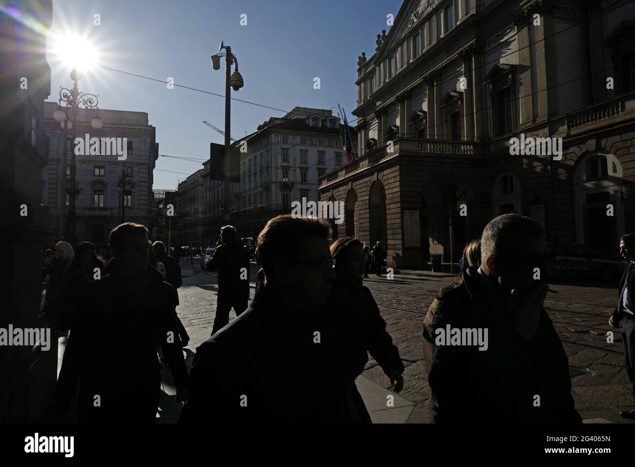 La gente cammina in piazza la Scala, con lo storico palazzo del teatro, in centro, Milano, Italia. Foto Stock