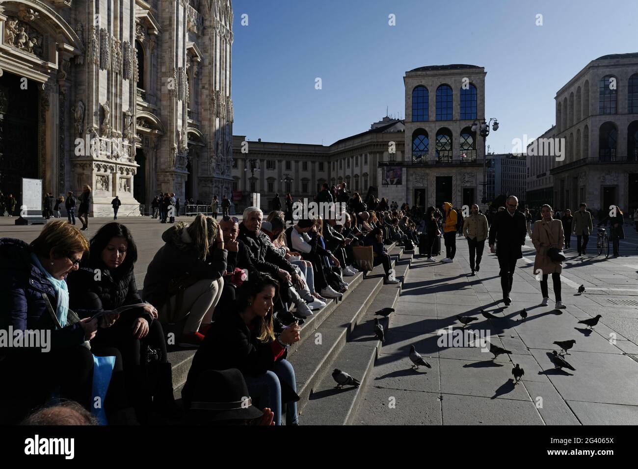 Posti a sedere sulla scalinata del Duomo, nel centro di Milano, Italia. Foto Stock