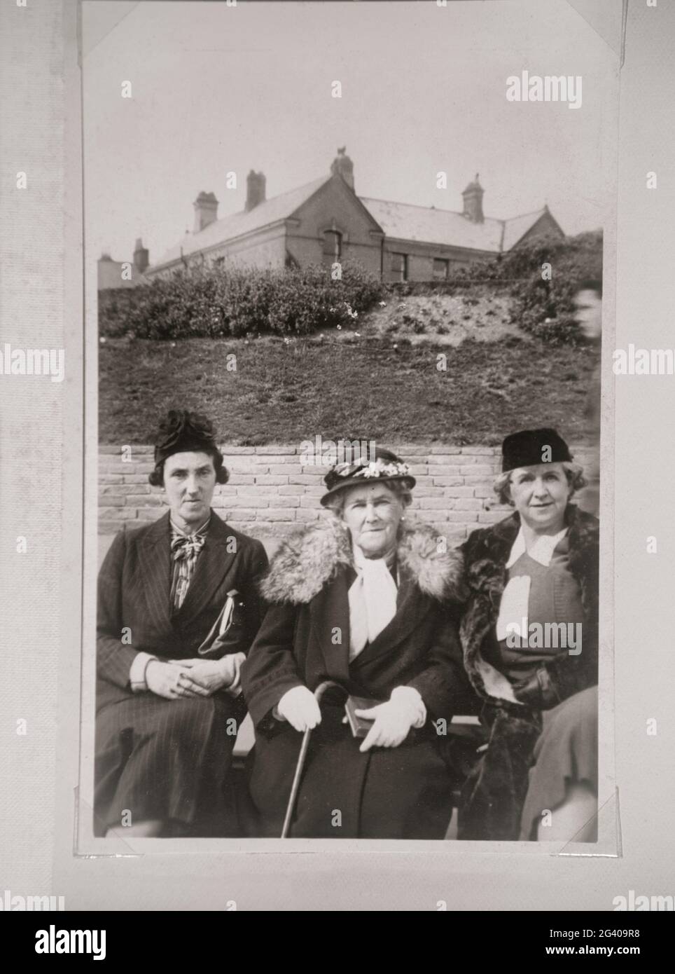 Autentica fotografia vintage di due giovani donne e di una donna anziana che indossa cappelli seduti insieme. Concetto di nostalgia, il passato, Foto Stock