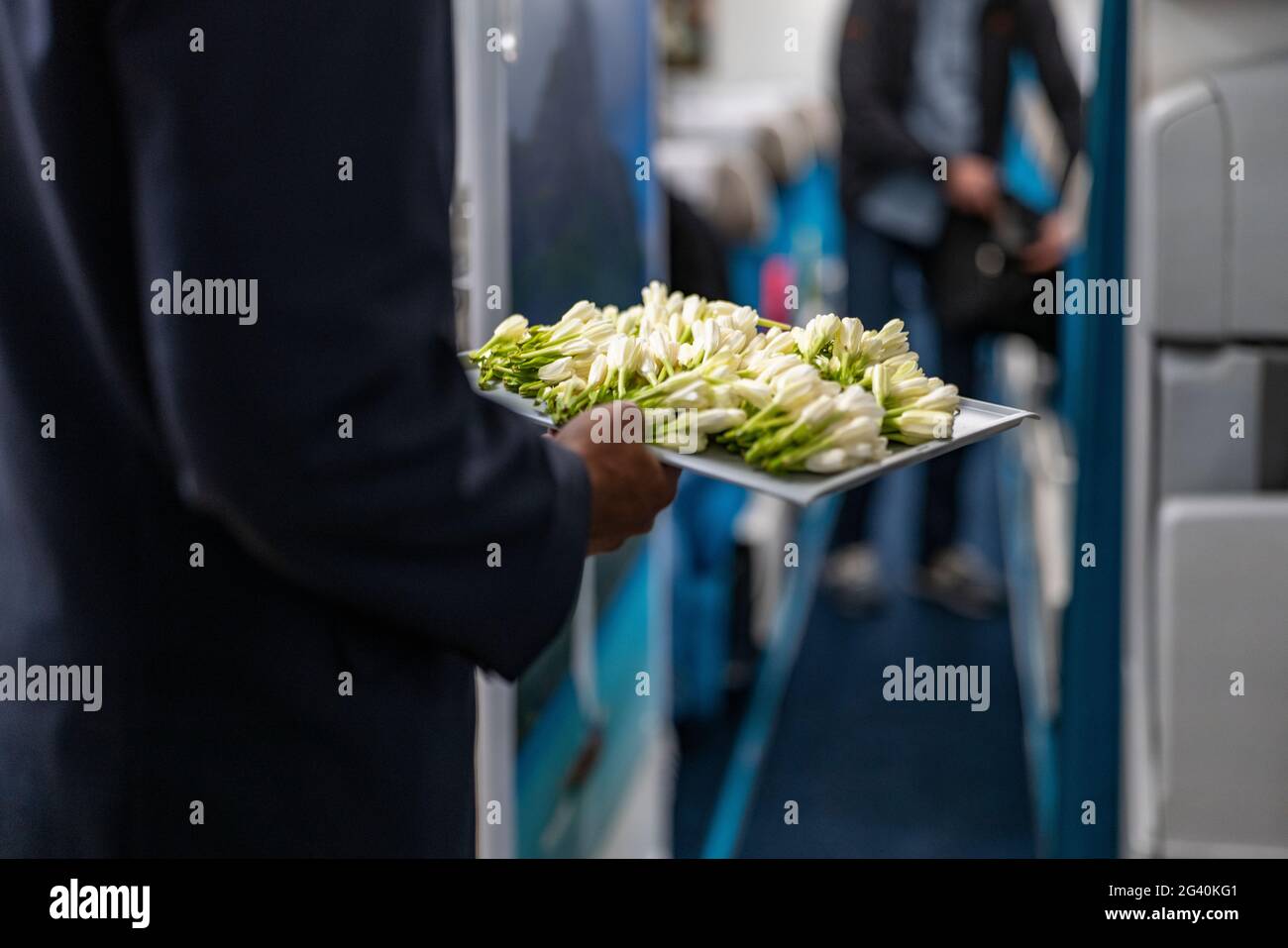 Assistenti di volo con vassoio di fiori di mare di Tahiti freschi salutano i passeggeri a bordo dell'aereo Air Tahiti Nui Boeing 787 Dreamliner, Paris Charles Foto Stock