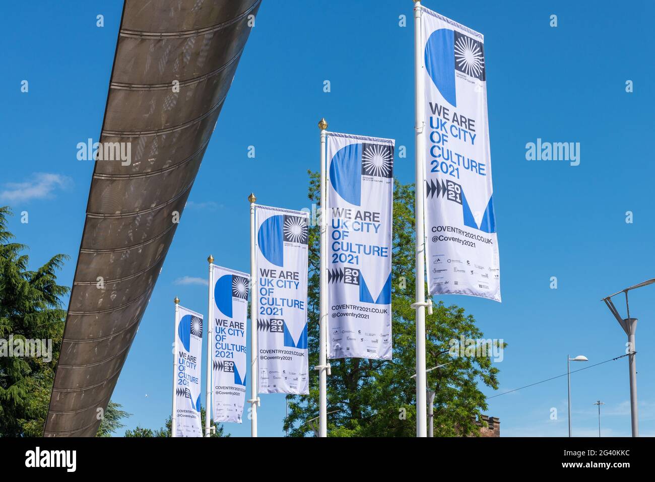 Fila di bandiere che celebrano Coventry essendo la Citta' della Cultura del Regno Unito accanto al Whittle Arch fuori dal Coventry Transport Museum Foto Stock