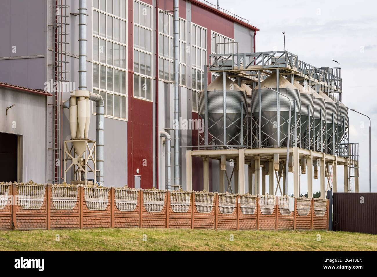 Moderno ascensore Granary e linea per la pulizia dei semi. Silos argentati su agro-lavorazione e impianto di produzione per la lavorazione essiccazione pulizia e stoccaggio di Foto Stock