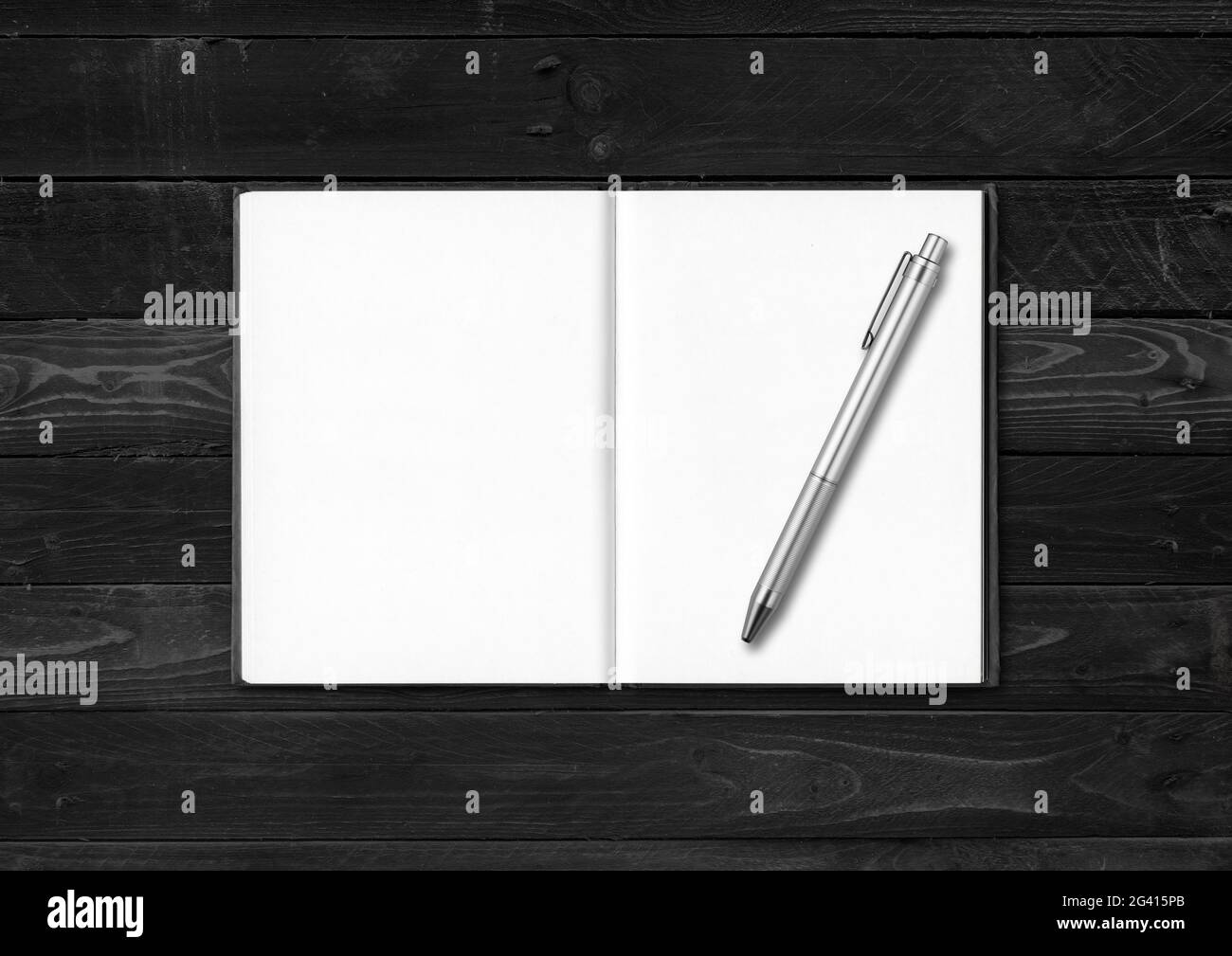 Notebook vuoto aperto e penna isolata su sfondo di legno nero Foto Stock