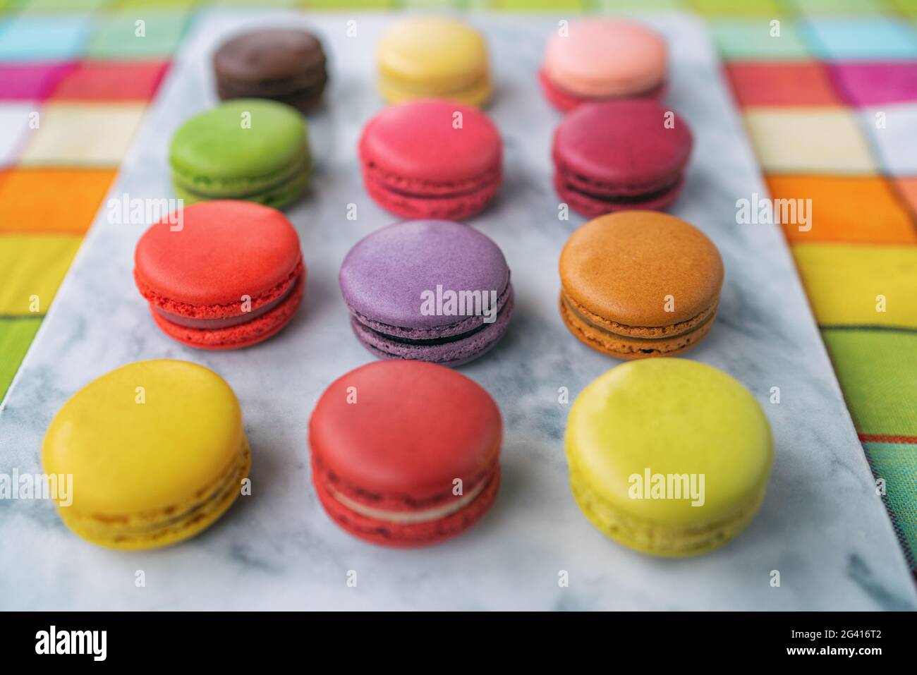 Macaron vista dall'alto su tavolo in marmo. Cottura di ricette fatte in casa fresco dal forno selezione di macaroni pasticceria francese dolci biscotti Foto Stock