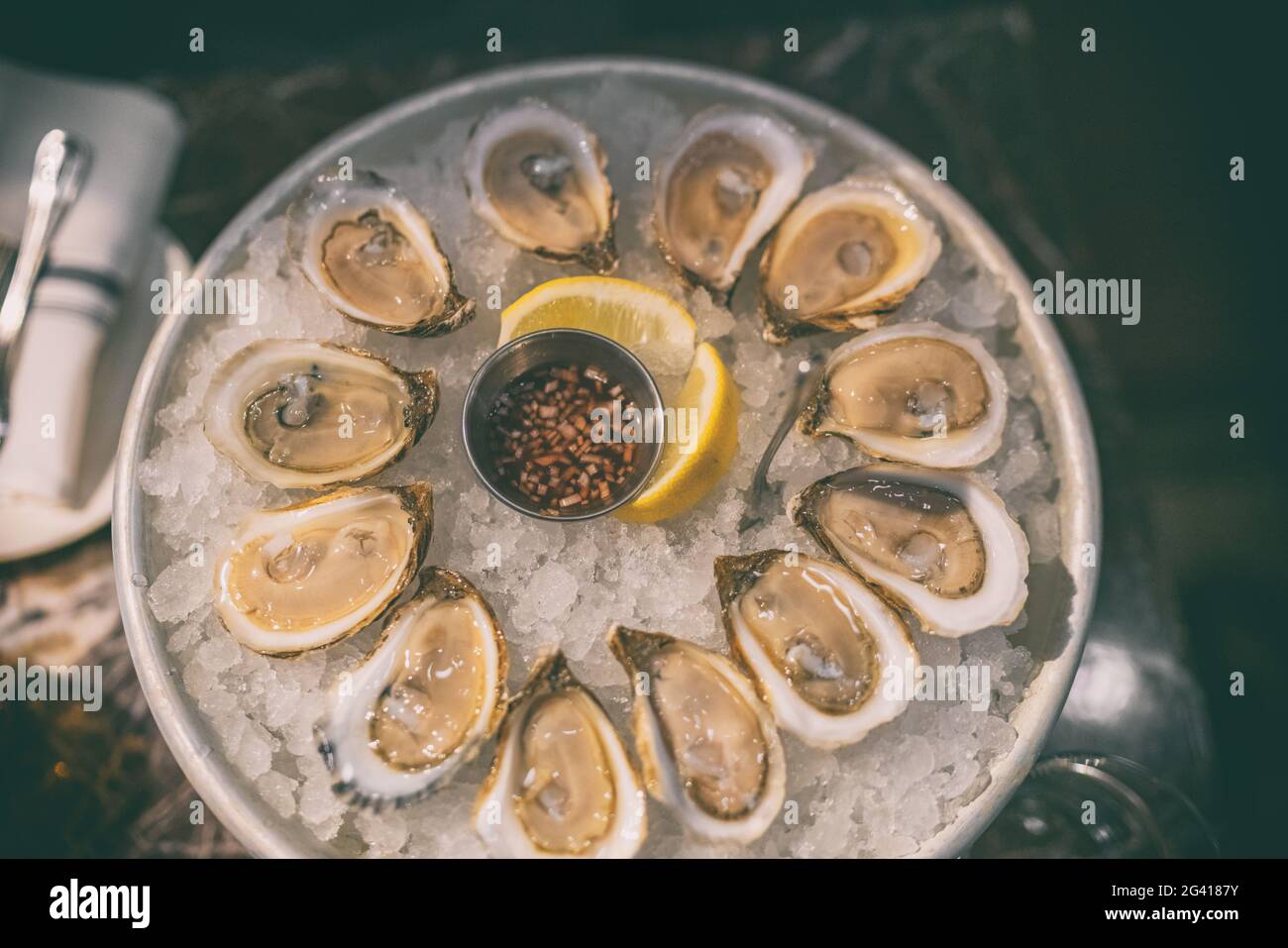 Piatto di ostriche al ristorante Oyster fresco su piatto di ghiaccio dal Canada. Vista dall'alto sul mare canadese Foto Stock