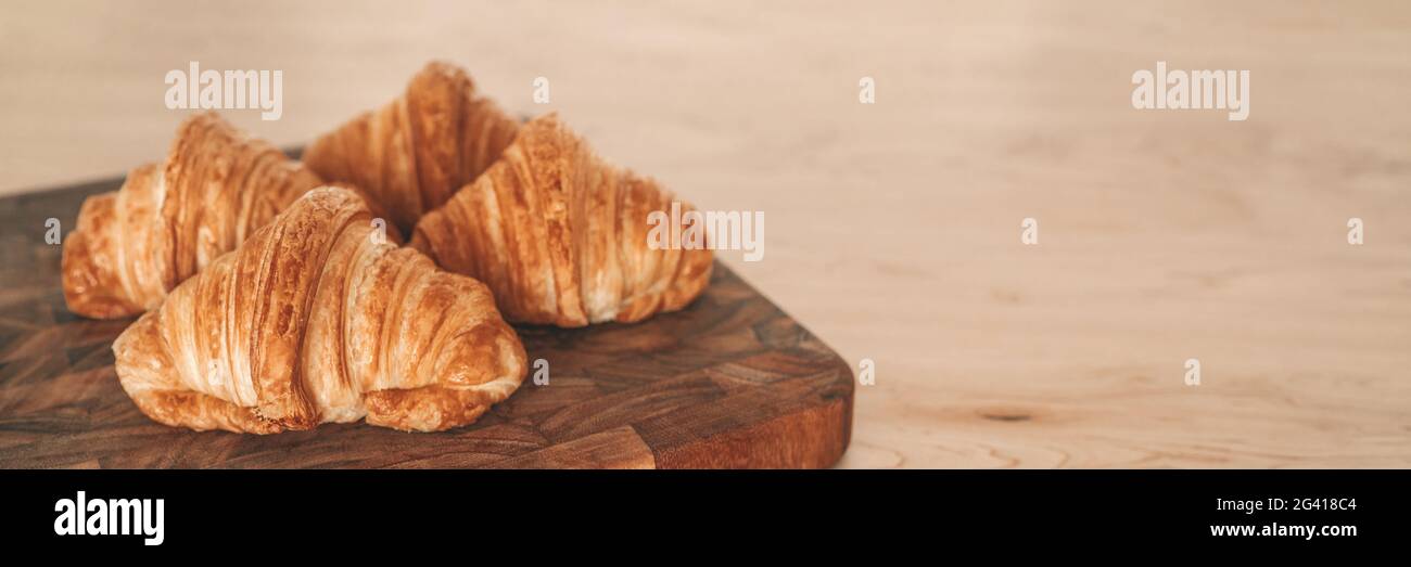 Croissant appena sfornati su fondo banner in legno. Pasticceria francese da panetteria Foto Stock
