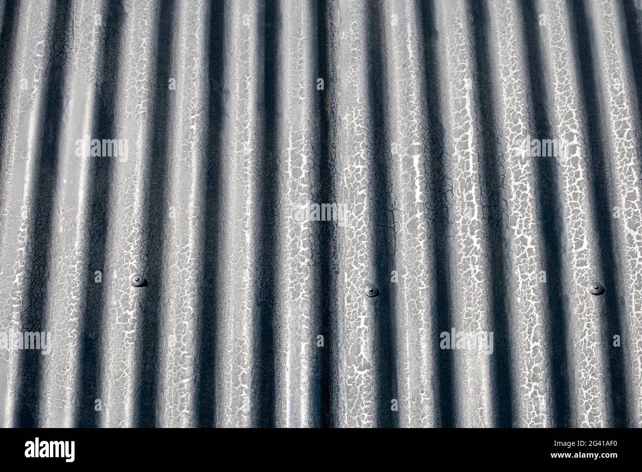 Particolare del tetto di fienile in ferro corrugato curvo contro un cielo blu Foto Stock