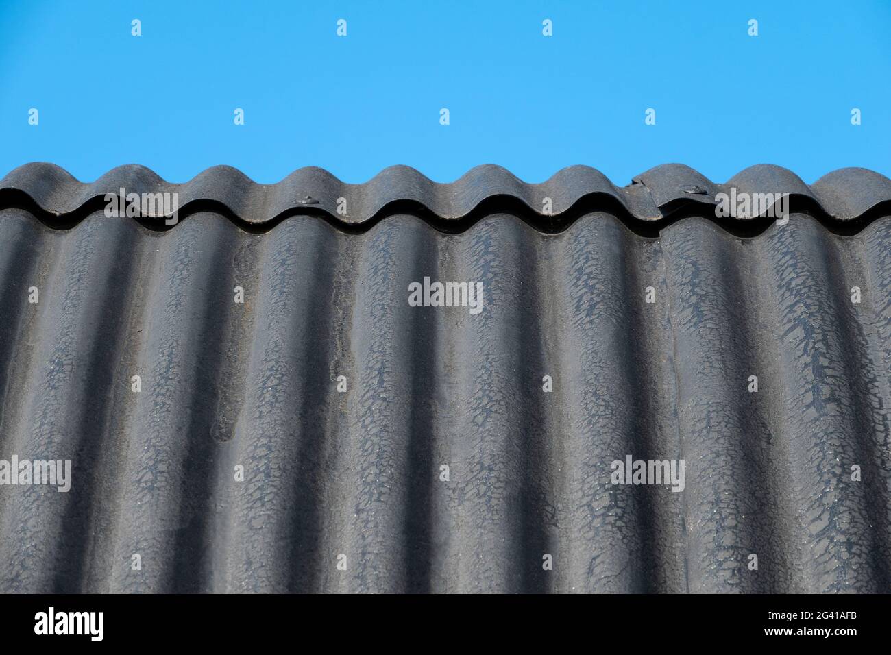 Particolare del tetto di fienile in ferro corrugato curvo contro un cielo blu Foto Stock