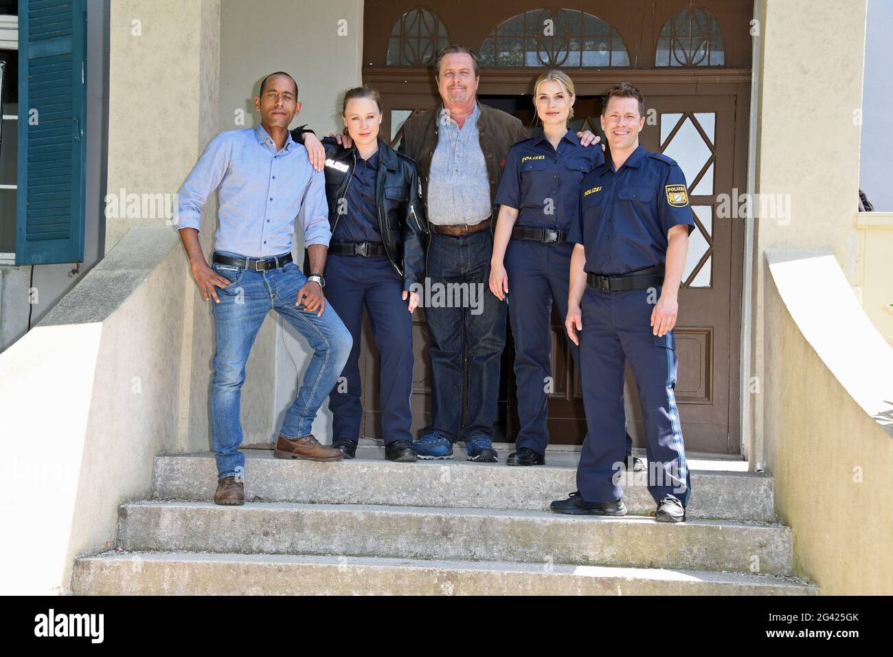 Geiselgasteig, Germania. 18 Giugno 2021. Gli attori Peter Marton (l-r, Jerry Paulsen), Katharina Leonore Goebel (investigatore Sophia Strasser), Andreas Giebel (detective capo Benedikt Beissl), Sarah Thonig (Caro Reiser), il regista John Delbridge e l'attore Firo Nepz (Max Ruffer) sorridono durante una pausa nelle riprese per la serie ARD 'Watmitzermann'. Credit: Ursula Düren/dpa/Alamy Live News Foto Stock