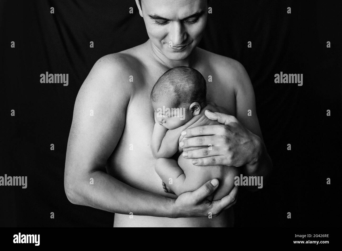 Padre che tiene la figlia appena nata ad un photoshoot neonato Foto Stock