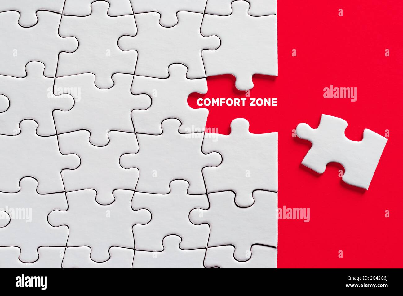 La parola zona comfort con pezzo di puzzle mancante su sfondo rosso. Foto Stock