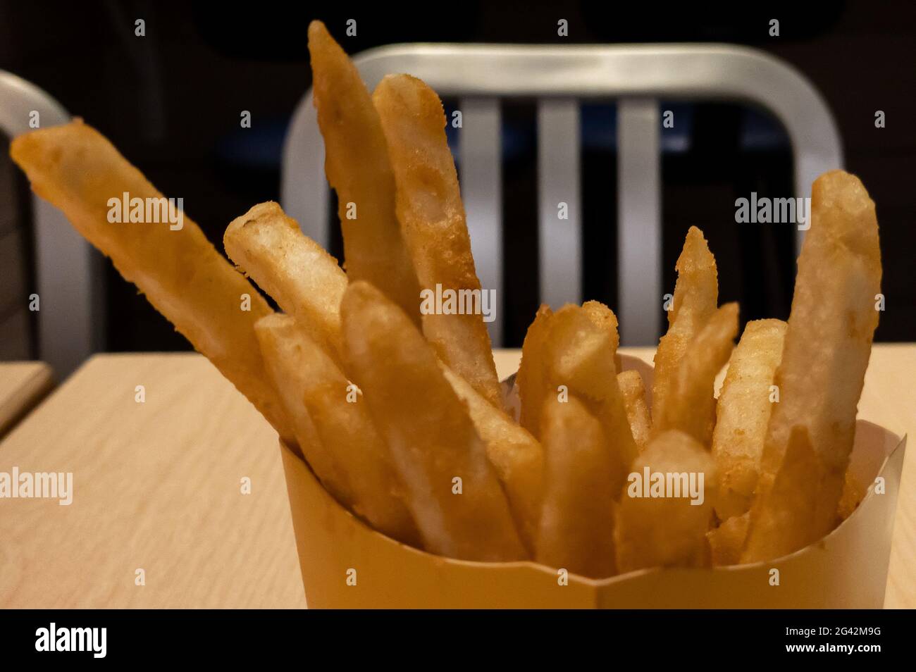 Ristorante che serve patatine fritte all'interno di un negozio di hamburger. Primo piano di gustosi spuntini di patate fritte. Fast food e concetto di alimentazione malsana Foto Stock