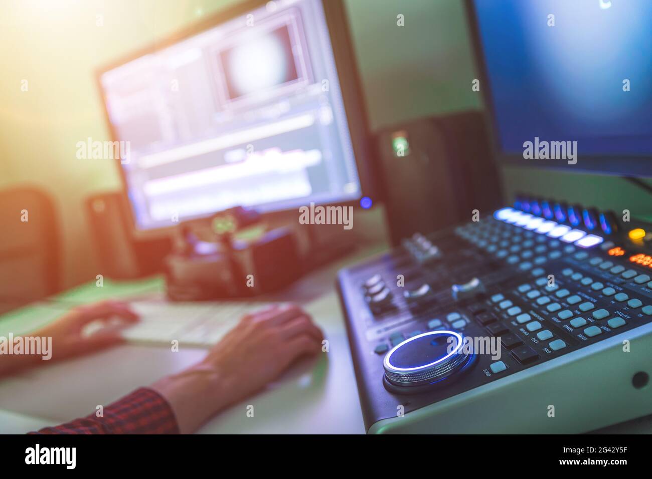 Sala di taglio professionale per l'editing video e la produzione video: Monitor e scrivania di mixaggio audio Foto Stock