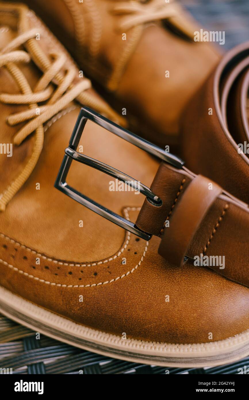 Cintura in pelle marrone con fibbia in metallo su stivali marroni da uomo  con lacci Foto stock - Alamy