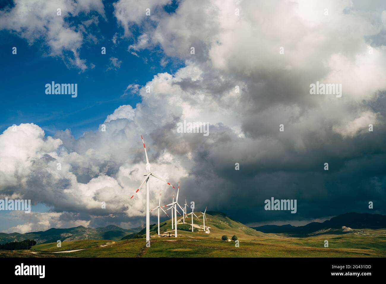 Molte turbine eoliche sulla collina, sullo sfondo di un cielo epico. Foto Stock