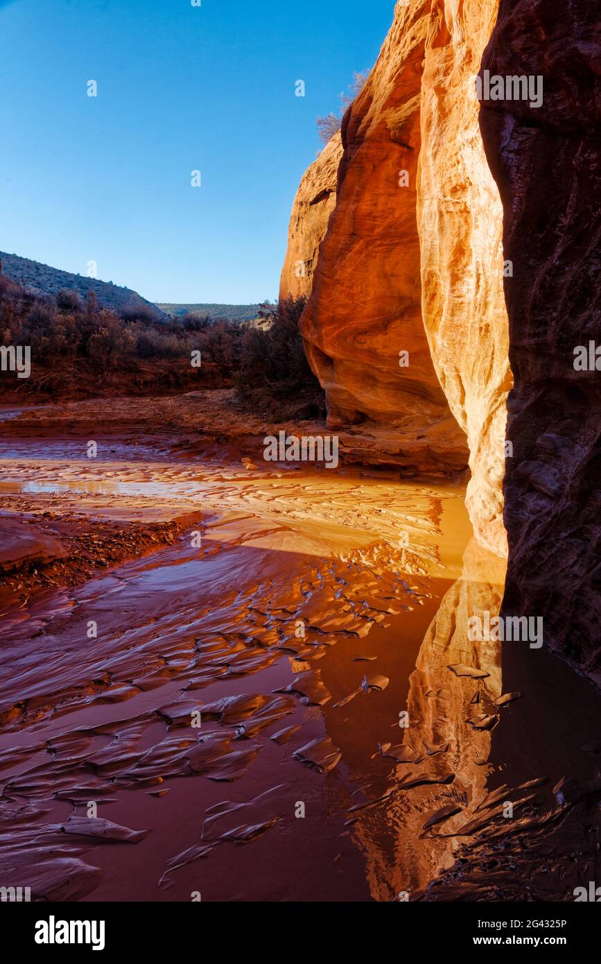 Formazioni rocciose di arenaria che si riflettono in acqua al tramonto, Utah, USA Foto Stock