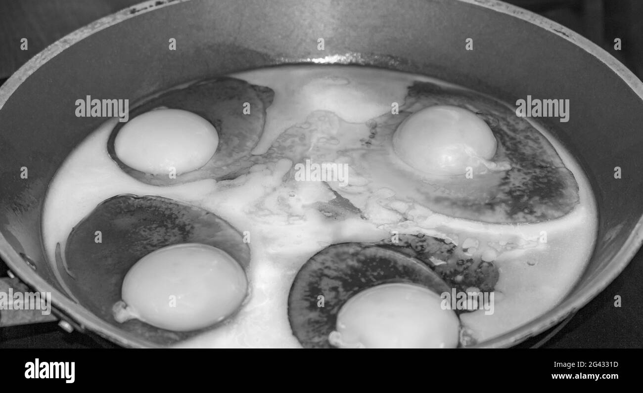 Immagine in bianco e nero di uova fritte e uova fritte in padella al mattino. Foto Stock