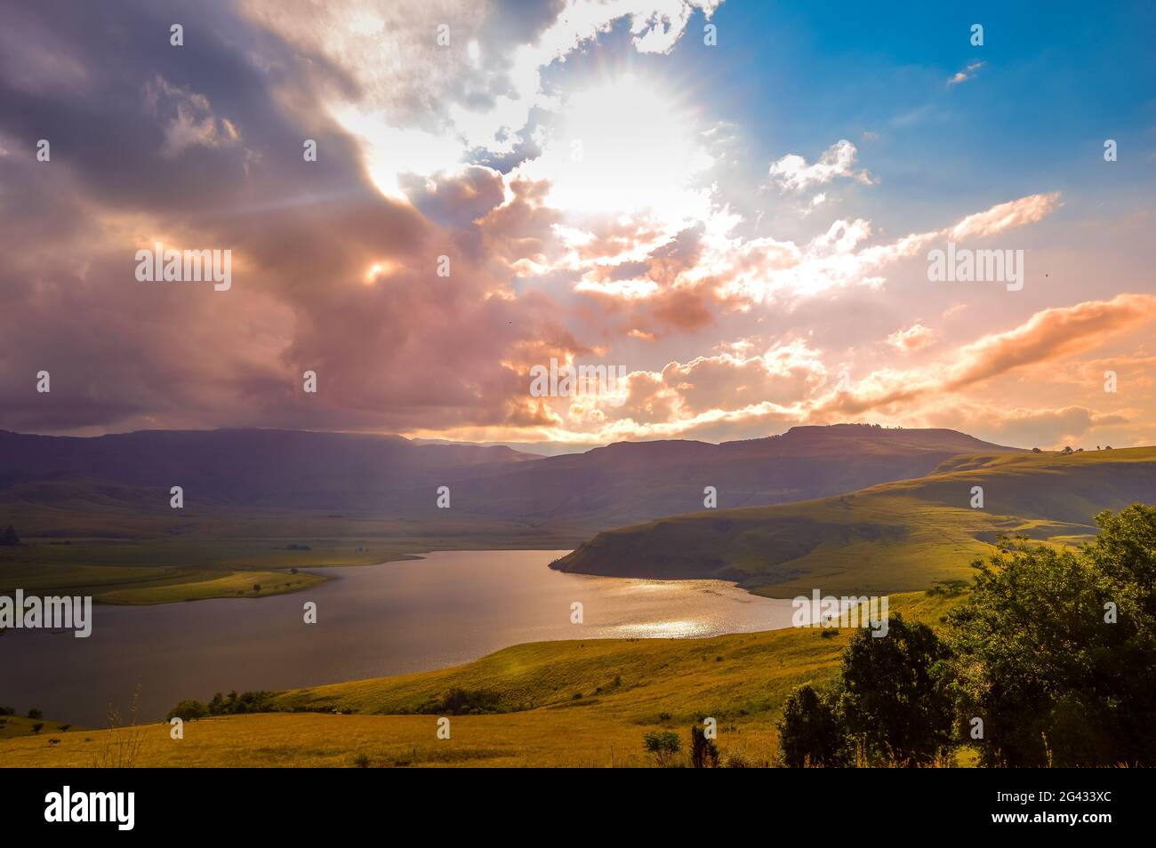 Drakensberg montagne e campana parco diga con luce solare durante il tramonto Foto Stock