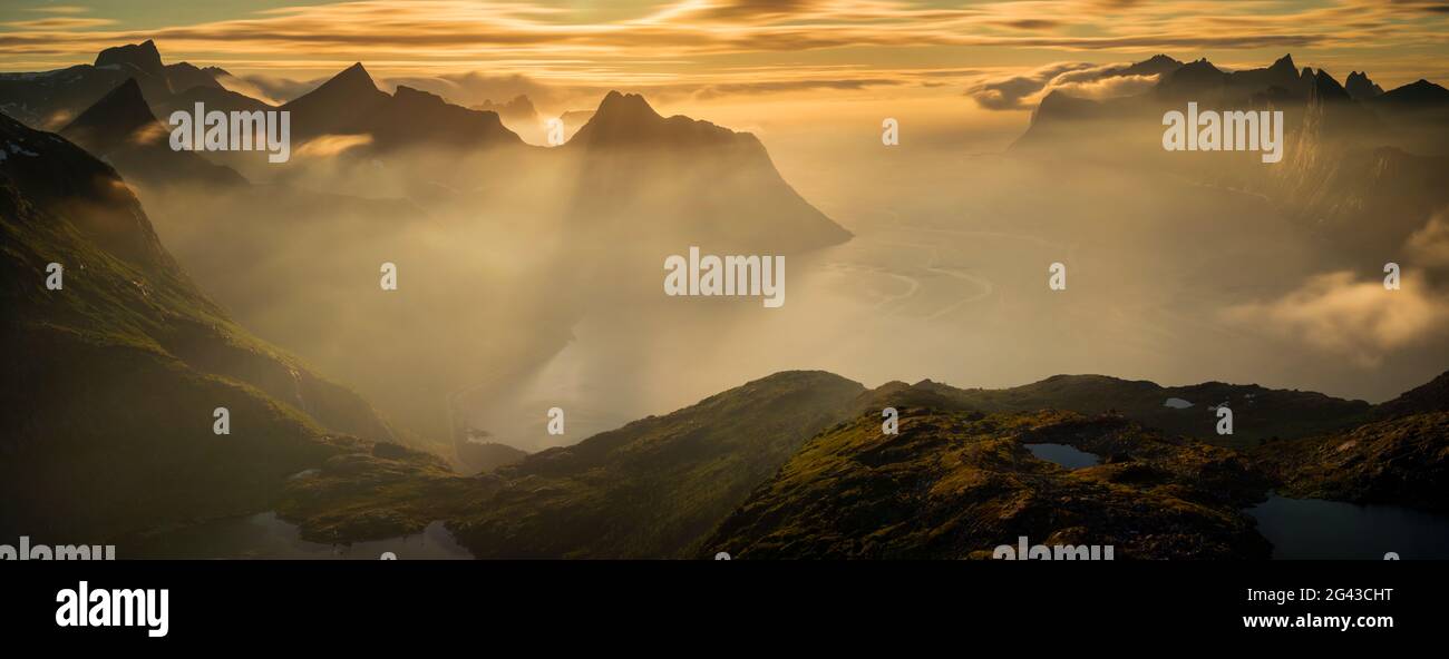Montagne e fiordi in nebbia all'alba, Mefjorden, Senja, Norvegia Foto Stock