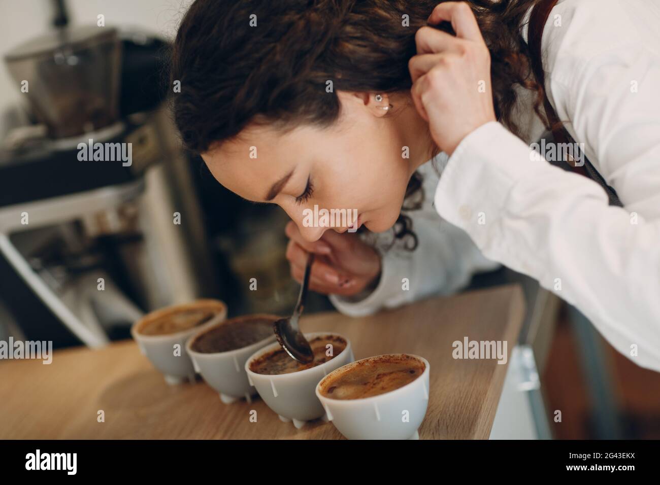 Tazza degustazione ragazza degustazione Degostation caffè prova di qualità. Tazza di caffè Foto Stock