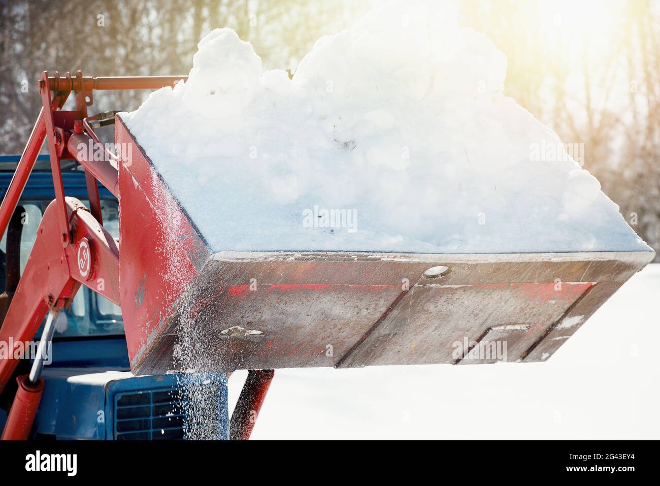 Trattore in una benna per togliere la neve. Sgombrare il territorio dagli effetti della nevicata. Foto Stock