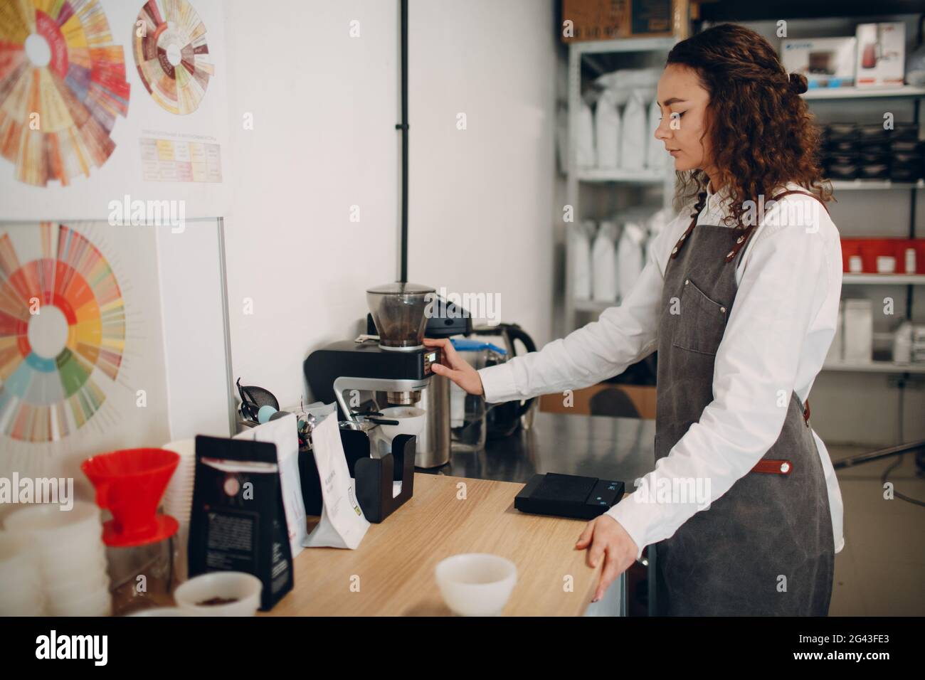 Tazza degustazione ragazza degustazione Degostation caffè prova di qualità. Barista giovane con macinacaffè Foto Stock