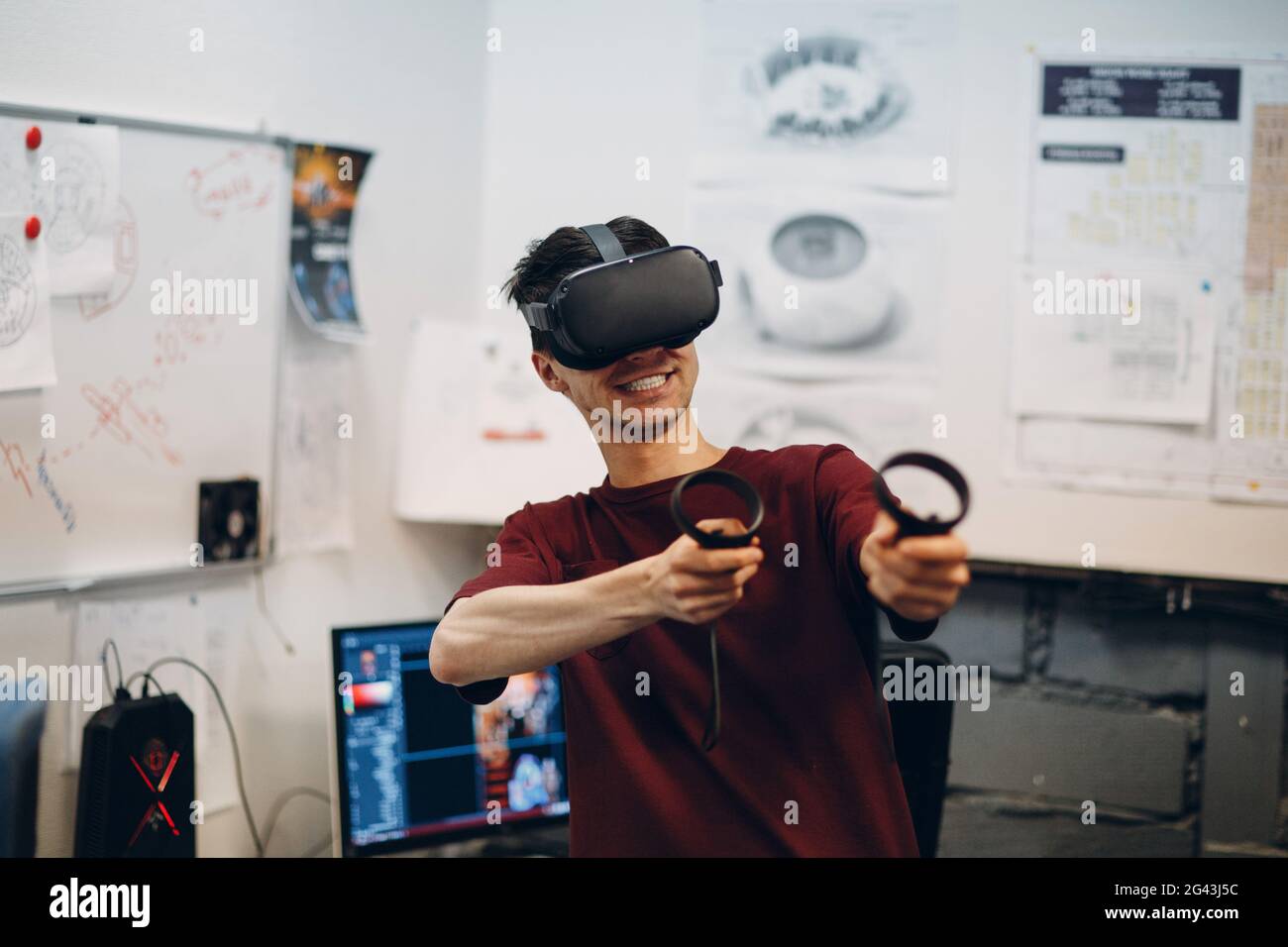 Giocatore giovane in occhiali per realtà virtuale, visore per occhiali VR con joystick Foto Stock