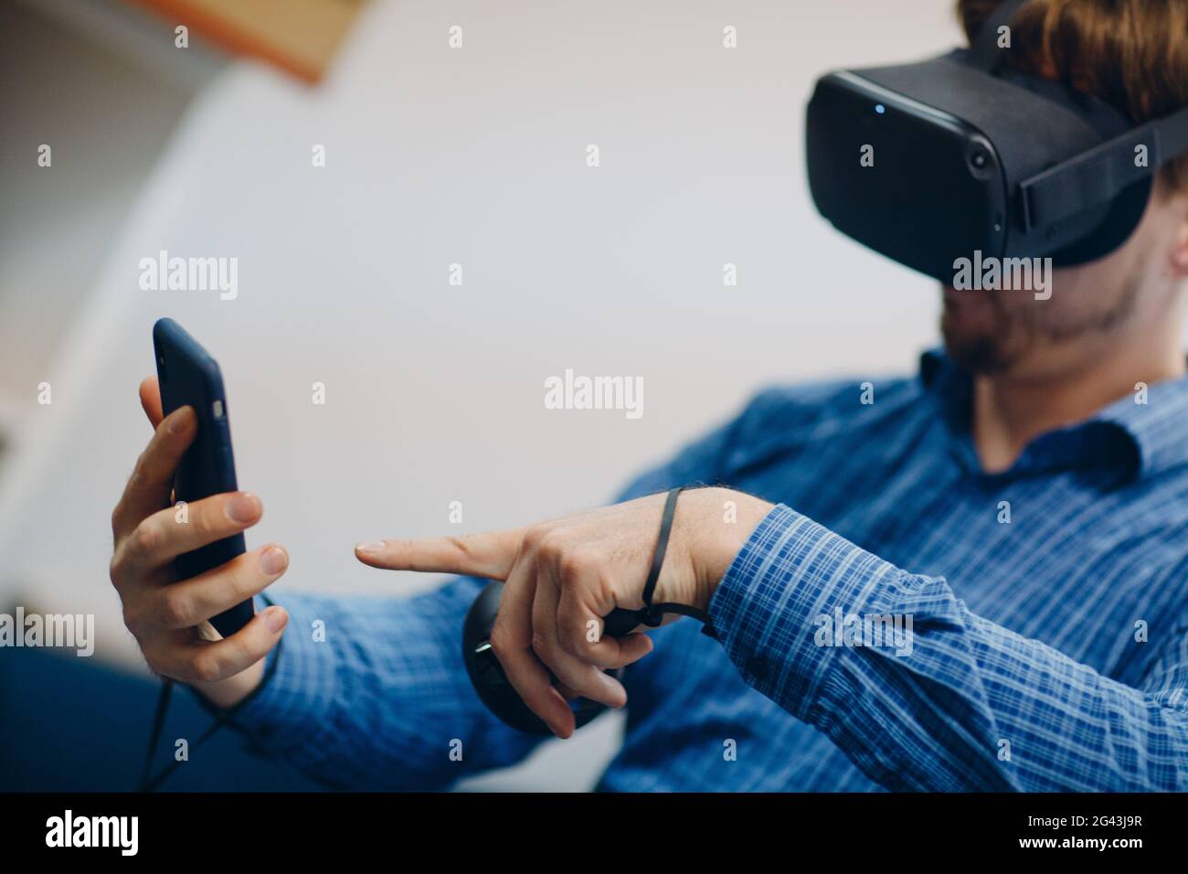 Giovane uomo con occhiali per realtà virtuale, visore per occhiali vr con joystick e telefono cellulare. Foto Stock
