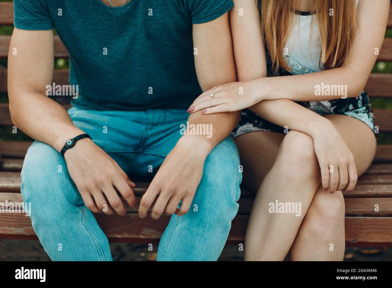 Storia d'amore. Giovane donna e uomo seduto sulla panchina. Lo tocchia. Foto Stock