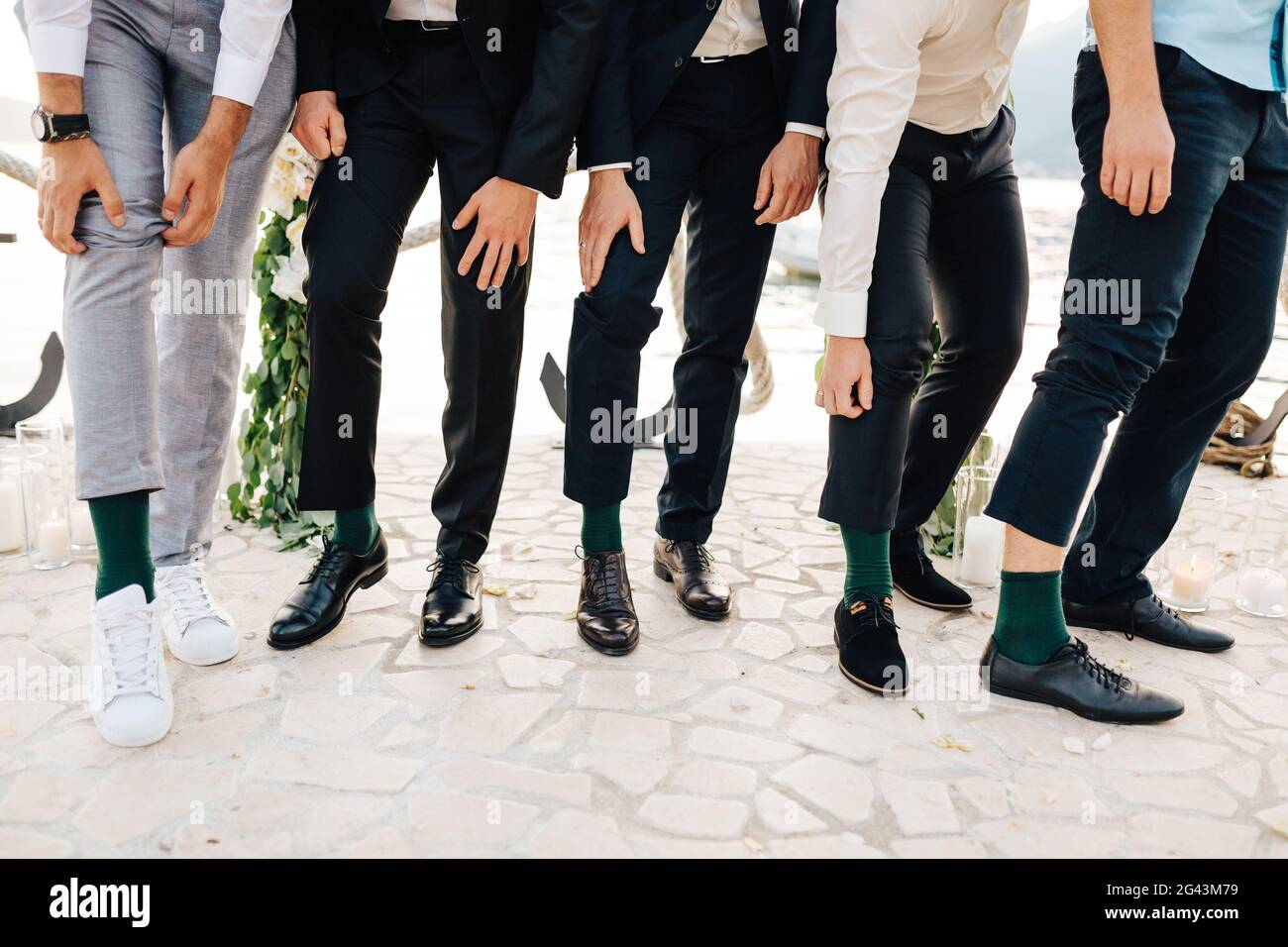Lo sposo e i migliori uomini mostrano che indossano le stesse calze verdi Foto Stock