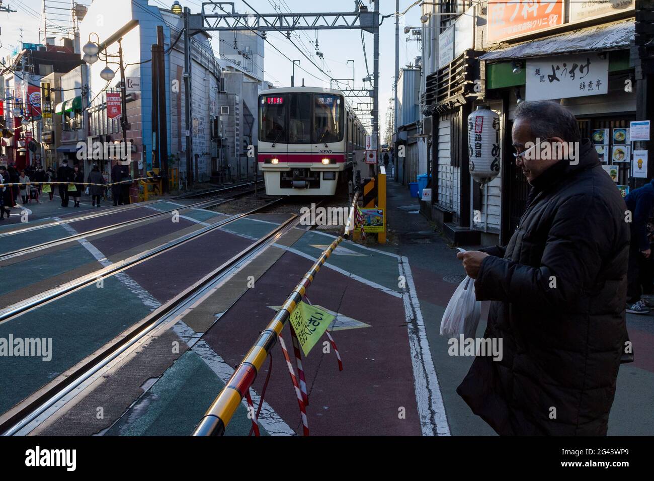 Un treno della serie Keio 8000 ad un passaggio a livello a Shimo-Takido, Tokyo, Giappone. Foto Stock