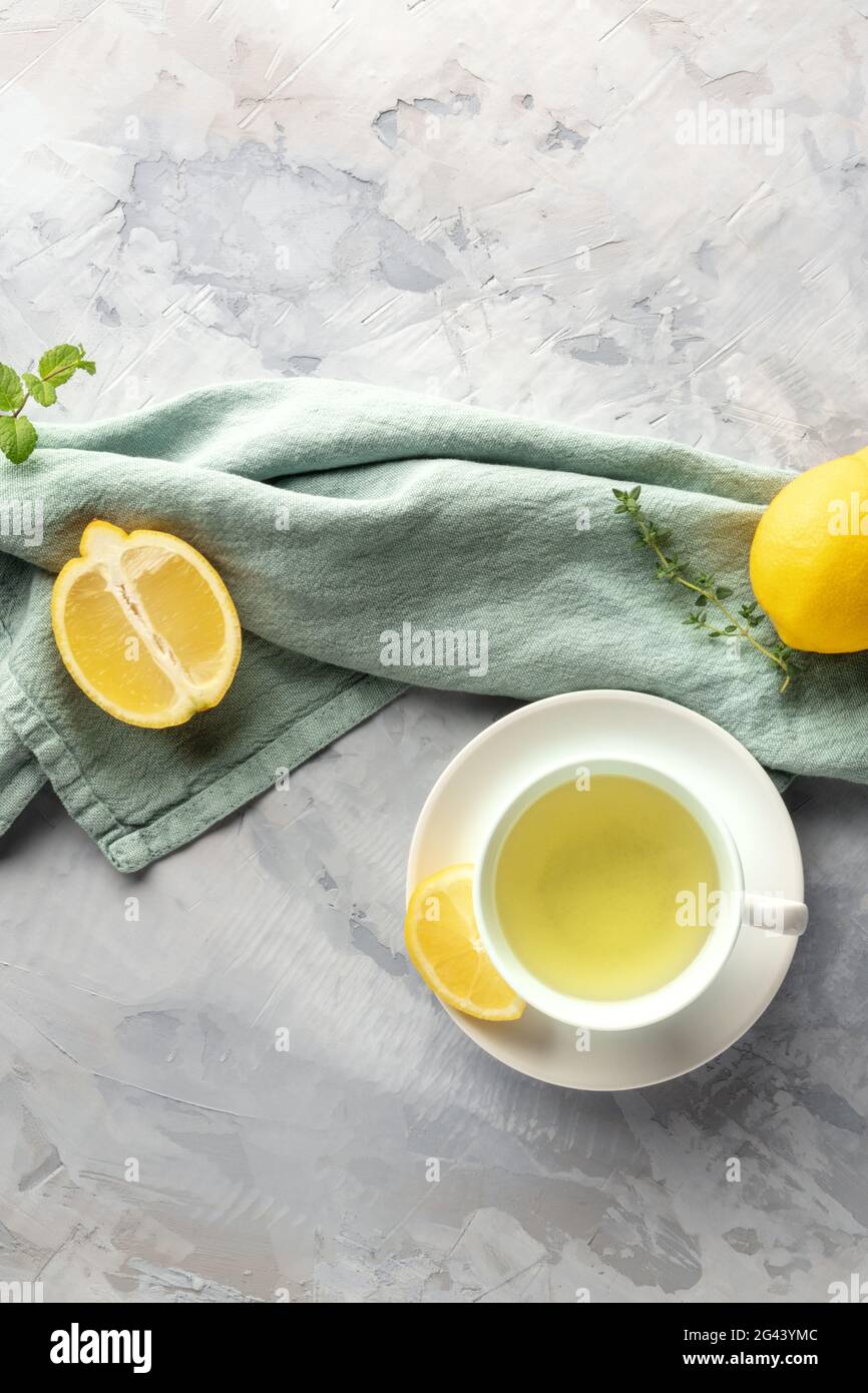 Una tazza di tè verde con limoni e erbe aromatiche, girato da sopra con lo spazio di copia Foto Stock