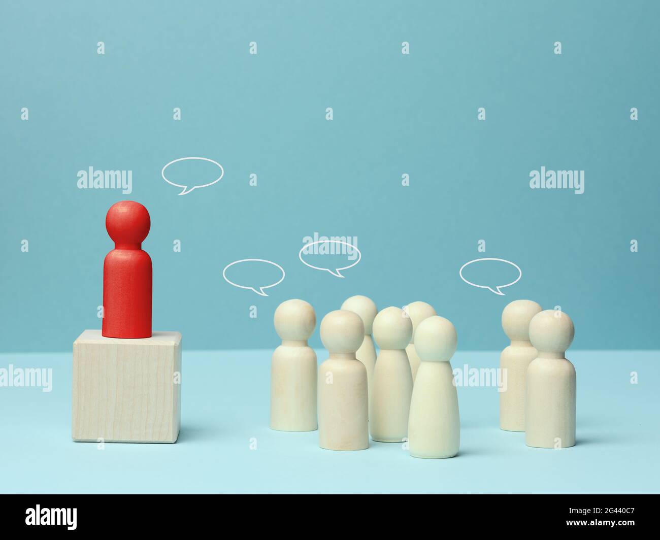 Figurine di legno di uomini su sfondo blu. Concetto di pubblico parlare, leadership e discussione Foto Stock