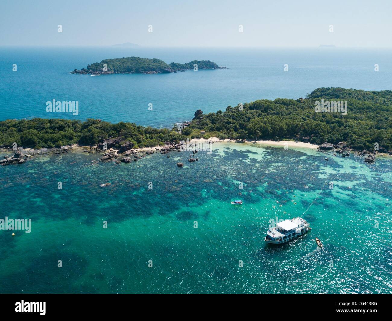 Vista aerea di John's Tours n° 9 escursione in barca e turisti snorkeling in acque cristalline vicino alla spiaggia con palme da cocco, Dam Ngang Island, vicino Phu Quoc Foto Stock