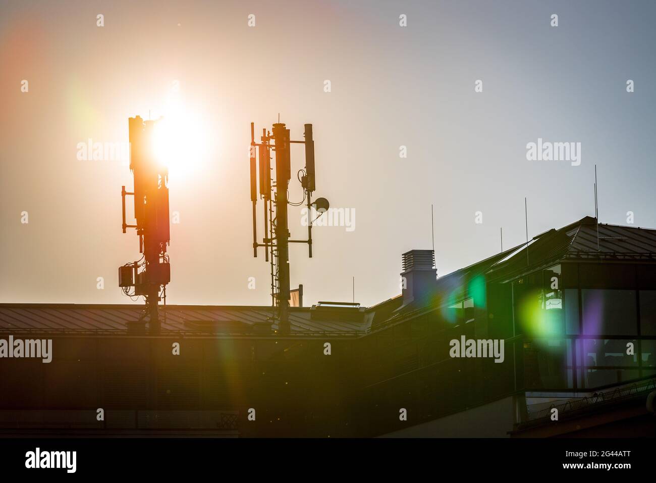 5g e torre di comunicazione: Profilo della torre di comunicazione sul tetto, sera Foto Stock