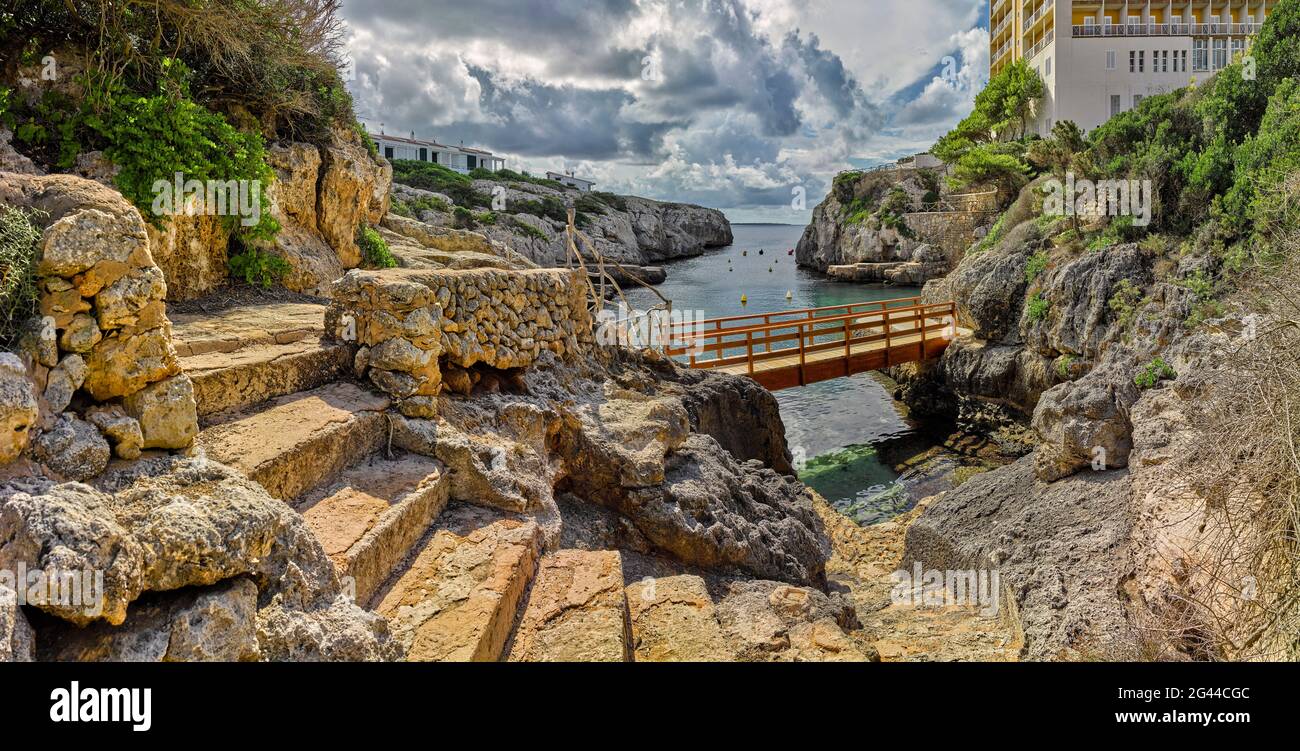 Paesaggio con piccola baia, scalini di pietra e costa rocciosa, Calan Forcat, Minorca, Spagna Foto Stock