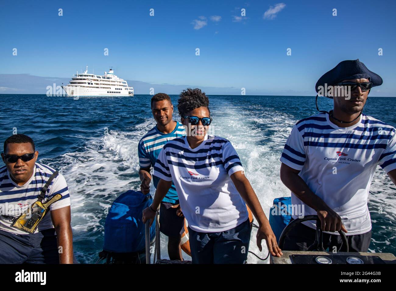 Quattro membri dell'equipaggio della nave da crociera MV Reef Endeavour (Captain Cook Cruises Fiji) sul battello a pagamento per il trasferimento, vicino all'Isola di Yangetta, al Gruppo di Yasawa, Fij Foto Stock