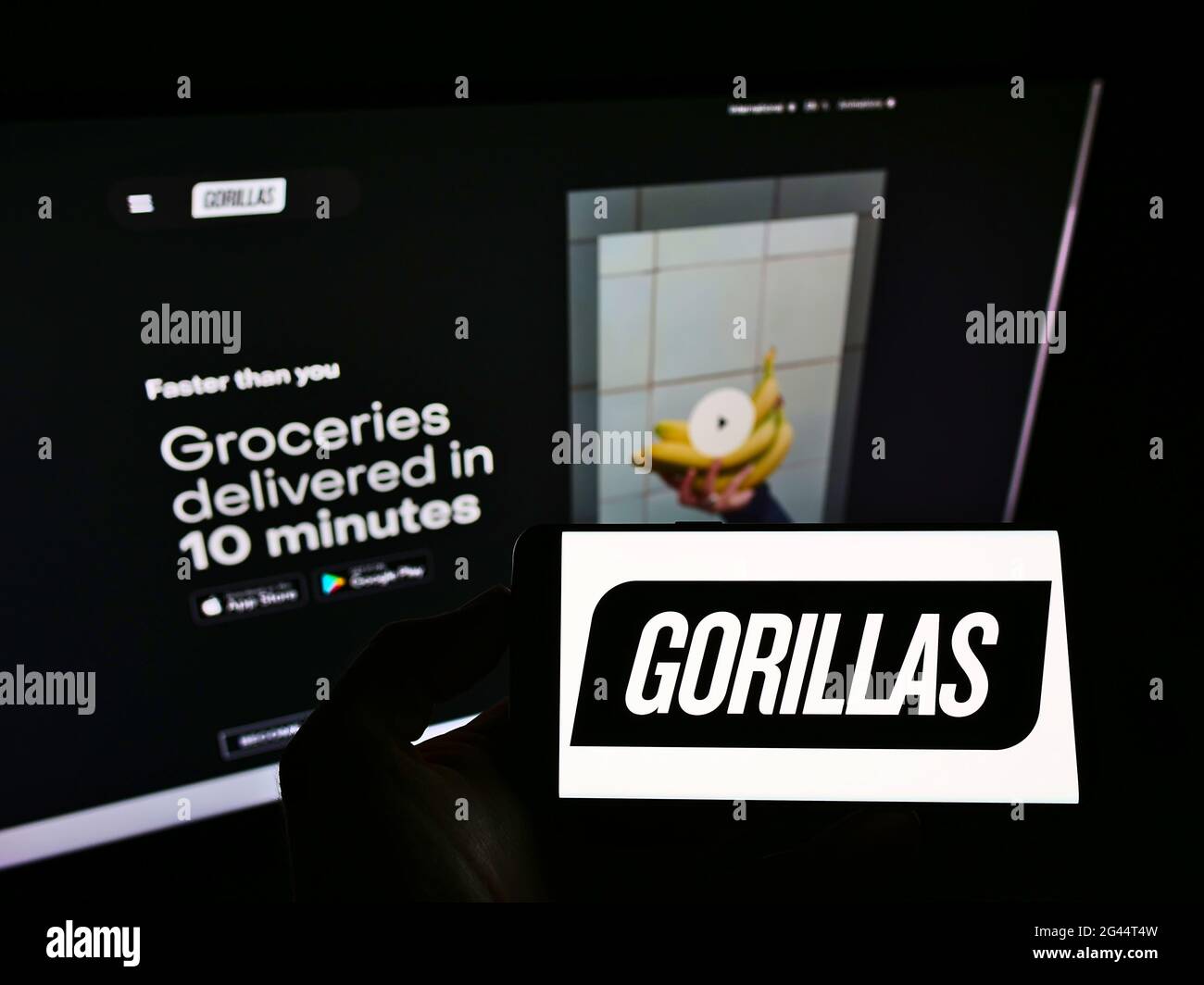 Persona che detiene smartphone con logo della società di consegna tedesca Gorillas Technologies GmbH sullo schermo di fronte al sito web. Mettere a fuoco il display del telefono. Foto Stock