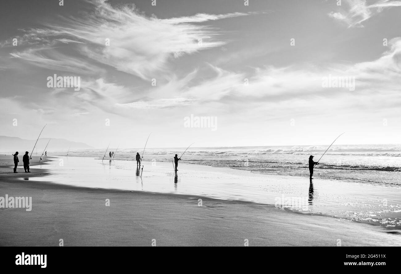 Gruppo di pescatori in spiaggia in bianco e nero Foto Stock