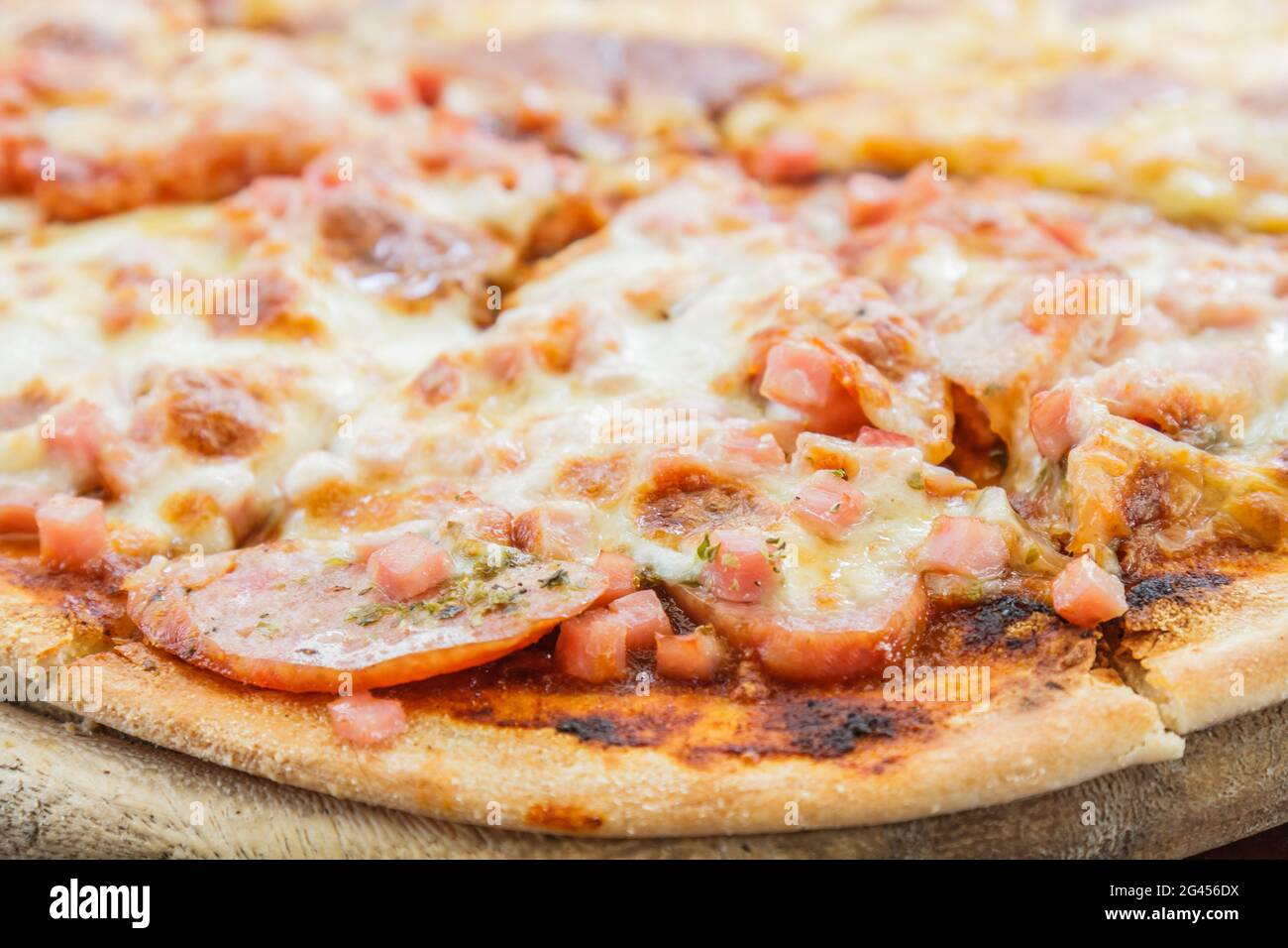 Pizza amante della carne con salsiccia, salame, prosciutto, pancetta, salsiccia per pizza e formaggio nel ristorante. Foto Stock