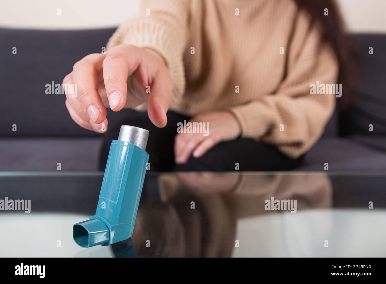 Giovane donna in cerca di un inalatore per asma durante un forte attacco di asma, non può respirare, concetto di salute Foto Stock