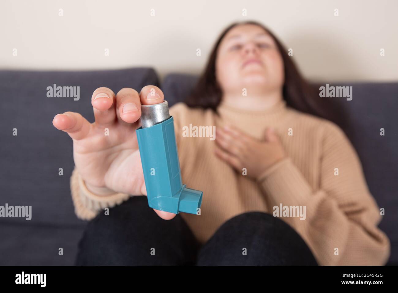Giovane donna in cerca di un inalatore per asma durante un forte attacco di asma, non può respirare, concetto di salute Foto Stock