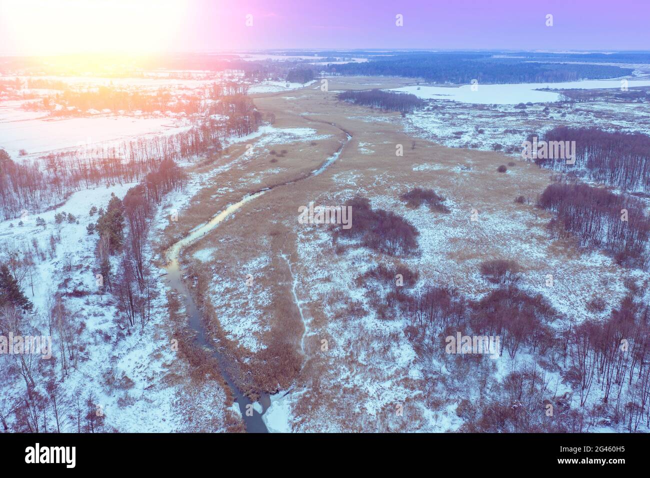 Vista aerea del tortuoso torrente nel prato al tramonto invernale Foto Stock