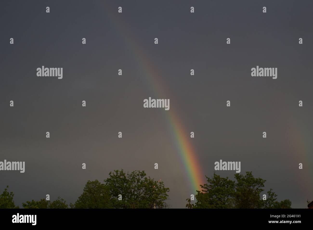 Arcobaleno di fronte al cielo grigio Foto Stock