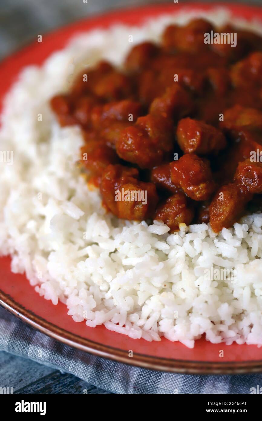 Riso vegano al curry su un piatto. Riso bianco con curry con carne di soia. Pranzo vegano. Cibo sano. Foto Stock