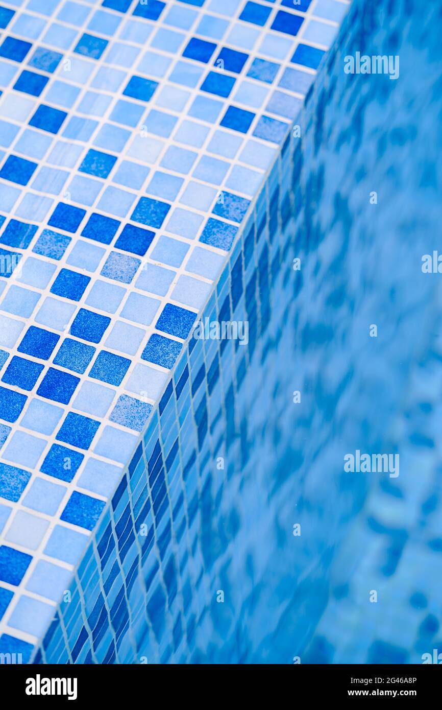 Scale di sfondo con piastrelle di mosaico blu di una piscina vicino l'acqua Foto Stock