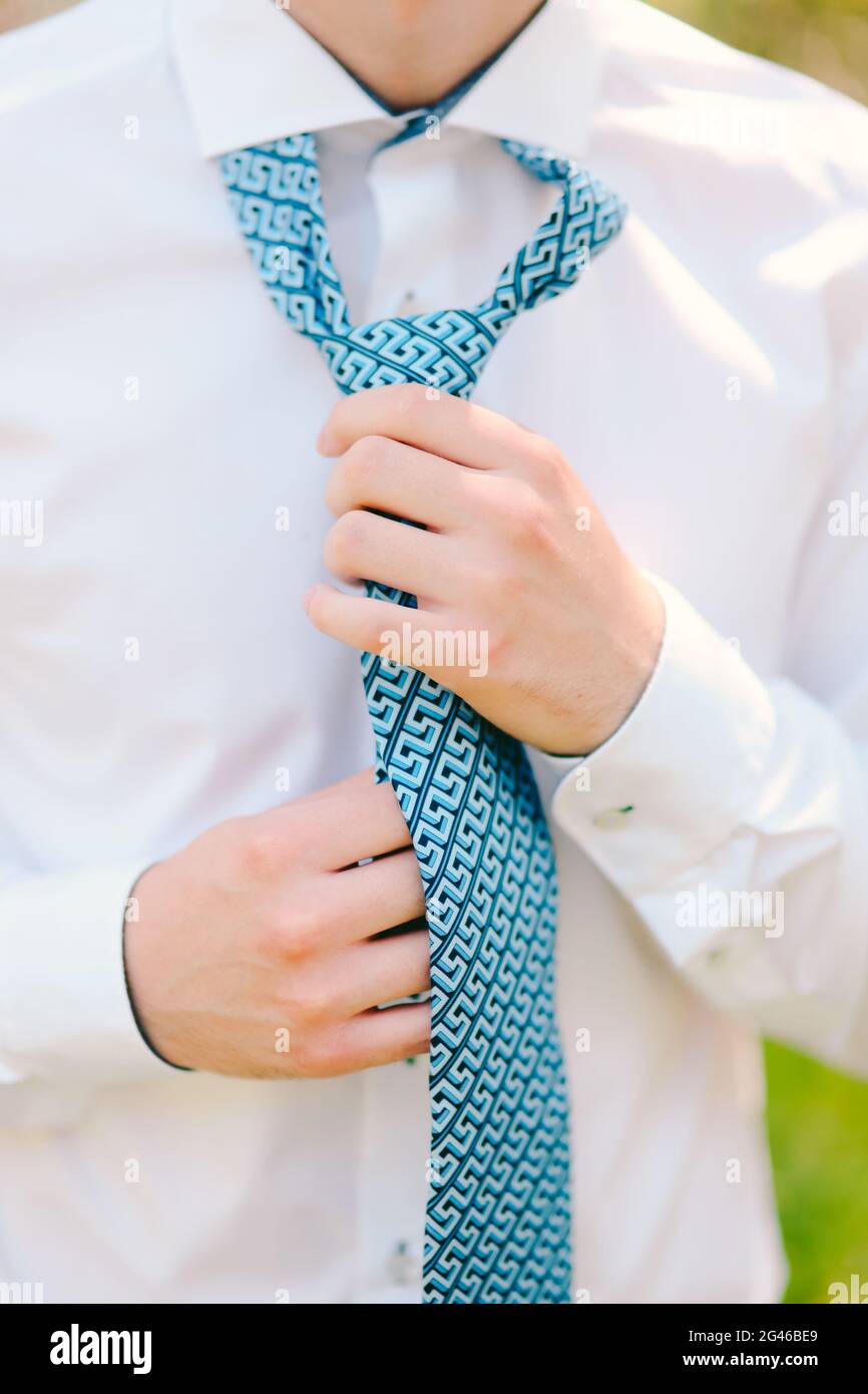 Uomo legando la sua cravatta. Lo sposo legando la sua cravatta. Accesso per sposi nuziali Foto Stock